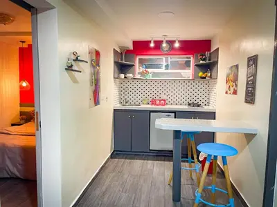 a small kitchen with a blue table and two stools at Red apartment excelente ubicacion Laurles Los molinos in Medellín