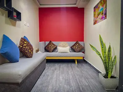 a living room with a couch and a red wall at Red apartment excelente ubicacion Laurles Los molinos in Medellín
