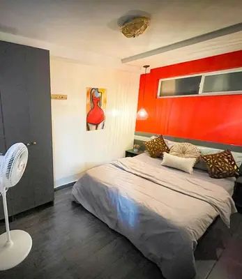 a bedroom with a bed with a red wall at Red apartment excelente ubicacion Laurles Los molinos in Medellín