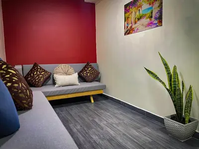 a room with a couch with pillows and a plant at Red apartment excelente ubicacion Laurles Los molinos in Medellín