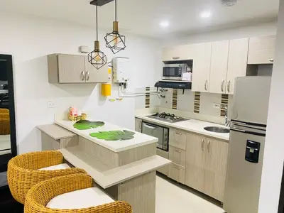 a kitchen with a counter and some chairs in it at 1009 Apartamento acogedor en el poblado Medellín in Medellín