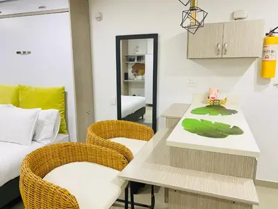 a room with a table and chairs and a bed at 1009 Apartamento acogedor en el poblado Medellín in Medellín