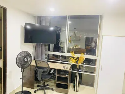 a room with a desk with a television and a chair at 1009 Apartamento acogedor en el poblado Medellín in Medellín
