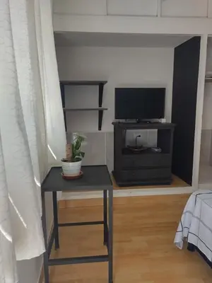 a living room with a table and a tv at Acogedor Apartaestudio Santa Fe in Medellín
