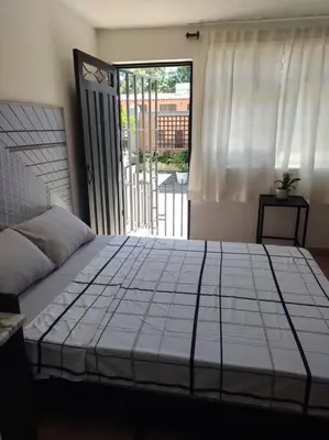a bedroom with a large bed with a large window at Acogedor Apartaestudio Santa Fe in Medellín