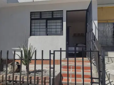 a fence in front of a house with a plant at Acogedor Apartaestudio Santa Fe in Medellín