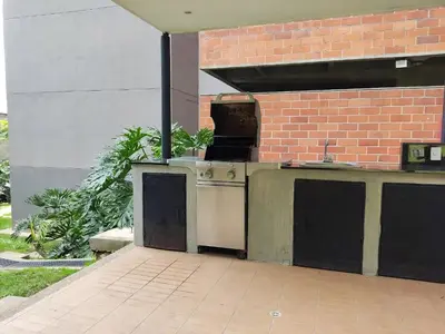 an outdoor kitchen with a stove and a brick wall at Apartamento con piscina, frente a CC Mayorca in Sabaneta