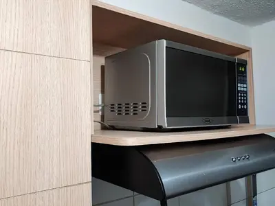 a microwave oven sitting on top of a counter at Apartamento con piscina, frente a CC Mayorca in Sabaneta