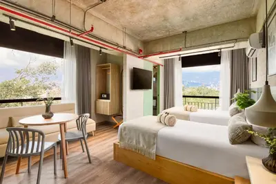 a hotel room with two beds and a table and a dining room at Urbit Social Lofts in Medellín