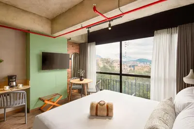 a hotel room with a bed and a large window at Urbit Social Lofts in Medellín
