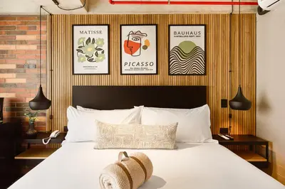 a bedroom with a bed with four pictures on the wall at Urbit Social Lofts in Medellín