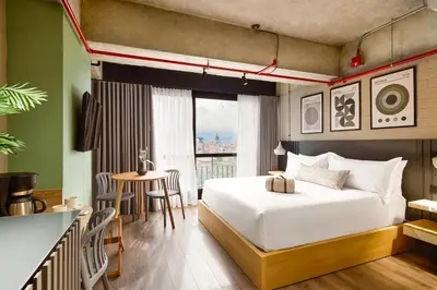 a hotel room with a bed and a table and a tableablish at Urbit Social Lofts in Medellín