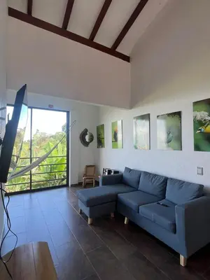 a living room with a blue couch and a large window at Campo Bonito in Jericó