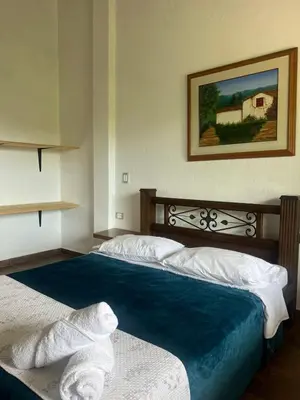 a bedroom with two beds and a painting on the wall at Campo Bonito in Jericó