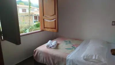 a bedroom with a bed with two pairs of shoes on it at Campo Bonito in Jericó
