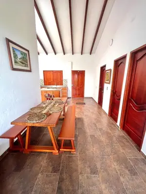 a dining room with a table and a kitchen at Campo Bonito in Jericó