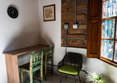 a room with two chairs and a desk and a clock at Casa Moore in Medellín