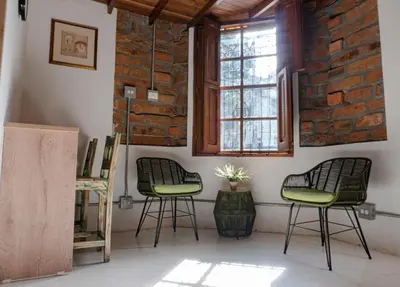 a room with two chairs and a brick wall at Casa Moore in Medellín