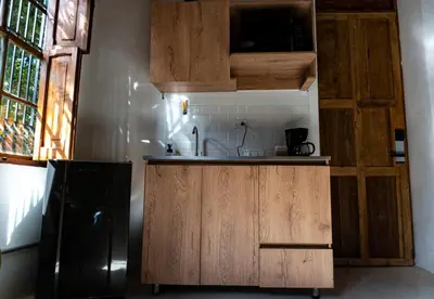 a kitchen with wooden cabinets and a black refrigerator at Casa Moore in Medellín