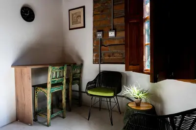 a room with two chairs and a desk and a table at Casa Moore in Medellín