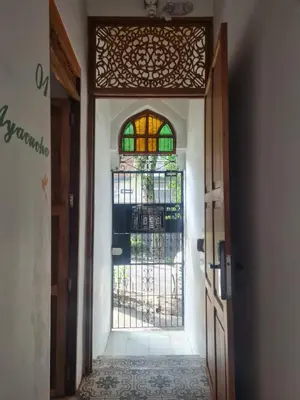 an open door with a gate and stained glass at Casa Moore in Medellín