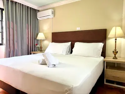 a bedroom with a large bed with white sheets at DUO BOUTIQUE HOTEL in Medellín