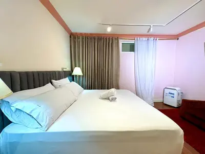 a bedroom with a large white bed and a window at DUO BOUTIQUE HOTEL in Medellín