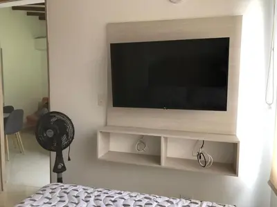a living room with a television on a wall at Cómodo apto para disfrutar su estadia in Medellín