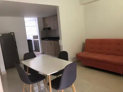 a living room with a table and chairs and a couch at Cómodo apto para disfrutar su estadia in Medellín
