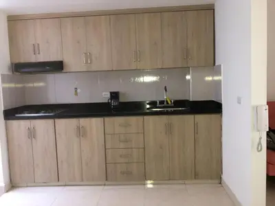 a kitchen with wooden cabinets and a sink at Cómodo apto para disfrutar su estadia in Medellín