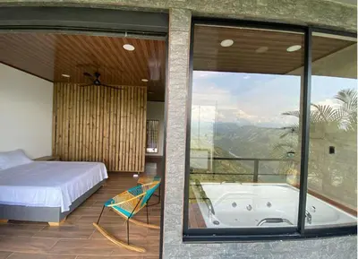 a bedroom with a tub and a bed and a window at AVANI Boutique Hotel in Norcasia
