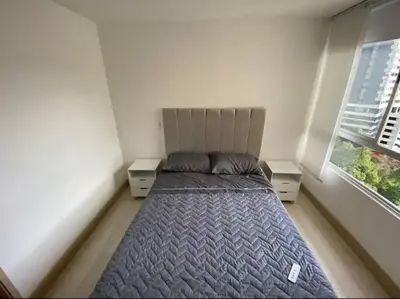 a bed in a small room with two windows at apto poblado a 8 min de provenza con free parking in Medellín