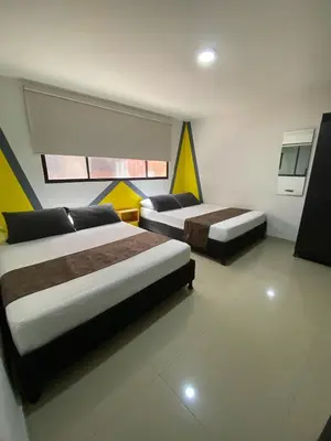 a hotel room with two beds and a tv at 33 Hotel Bulerias in Medellín