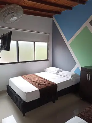 a bedroom with a bed and a window at 33 Hotel Bulerias in Medellín