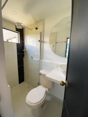 a bathroom with a toilet and a sink and a mirror at 33 Hotel Bulerias in Medellín