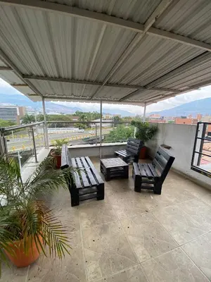 a patio with benches and tables on a roof at 33 Hotel Bulerias in Medellín
