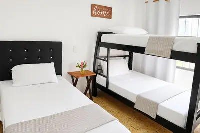 a room with three bunk beds and a table at Two modern furnished apartments in Medellín