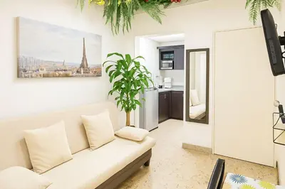 a living room with a white couch and a plant at Two modern furnished apartments in Medellín