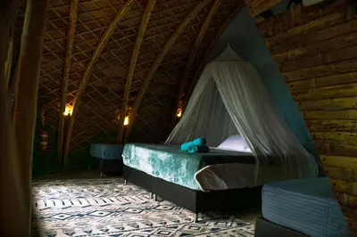 a bedroom with a bed with a mosquito net at Taibará Refugio Natural in San Carlos