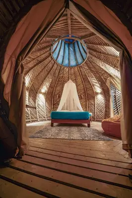 a room in a yurt with a blue couch in it at Taibará Refugio Natural in San Carlos