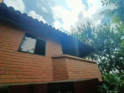 a brick building with a window on the side of it at Casa Campestre Poblado para 10H San Lucas 106 in Medellín