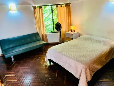 a bedroom with a bed and a green bench at Casa Campestre Poblado para 10H San Lucas 106 in Medellín