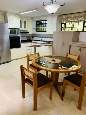 a kitchen with a table and two chairs and a kitchen with a refrigerator at Casa Campestre Poblado para 10H San Lucas 106 in Medellín