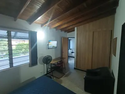 a bedroom with a door and a desk and a window at Acogedor Aparta Hotel 6H terraza Belén Rosales apt 300 in Medellín