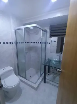 a bathroom with a shower and a toilet and a table at Acogedor Aparta Hotel 6H terraza Belén Rosales apt 300 in Medellín