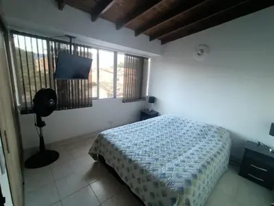 a bedroom with a bed and two windows and a television at Acogedor Aparta Hotel 6H terraza Belén Rosales apt 300 in Medellín