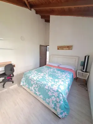 a bedroom with a bed and a desk and a tv at Apartamento en el Estadio-Obelisco in Medellín