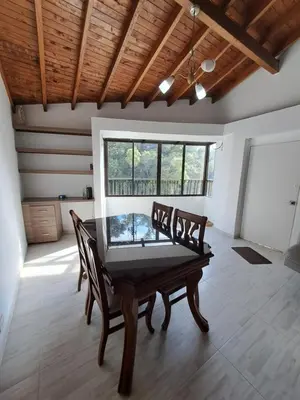 a dining room with a wooden table and chairs at Apartamento en el Estadio-Obelisco in Medellín