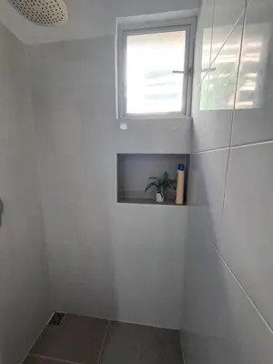 a white bathroom with a window and a plant at Apartamento en el Estadio-Obelisco in Medellín