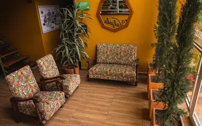 a waiting room with two chairs and a chair and a mirror at Hotel Valjala in Manizales